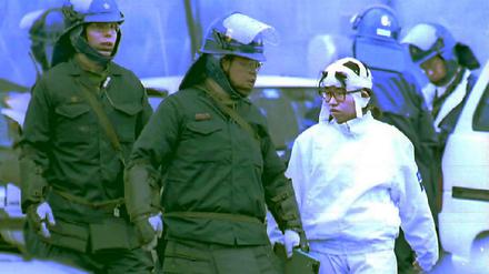Polizisten führen im März 1995 ein Mitglied (r) der Aum-Shinrikyo-Sekte aus dem Sektendorf Kamikuishiki. Bei einer großangelegten Razzia wurde der Sektenführer sowie weitere fünf Sektenmitglieder verhaftet. 