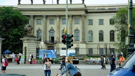 Das Hauptgebäude der Humboldt-Universität, eine Ampel auf der anderen Straßenseite steht auf Rot.