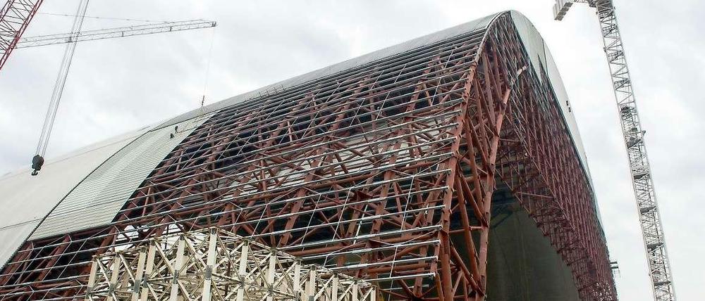 Diese gigantische Traglufthalle aus Stahl soll über den havarierten Reaktor vier des Atomkraftwerks Tschernobyl geschoben werden, und die dort lagernden rund 1,5 Tonnen strahlenden Staubs etwa 100 Jahre halbwegs sicher einschließen. Fertig ist der Bau frühestens 2017.