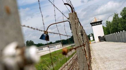 Ein Zaun und ein Wachturm an der Gedenkstätte des Konzentrationslagers Dachau.