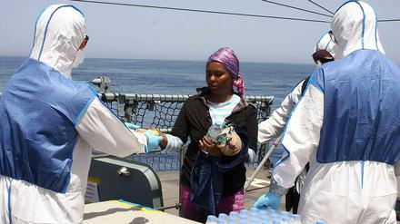 Personal der Bundeswehr verteilt auf der Fregatte "Hessen" Wasser an gerettete Flüchtlinge.