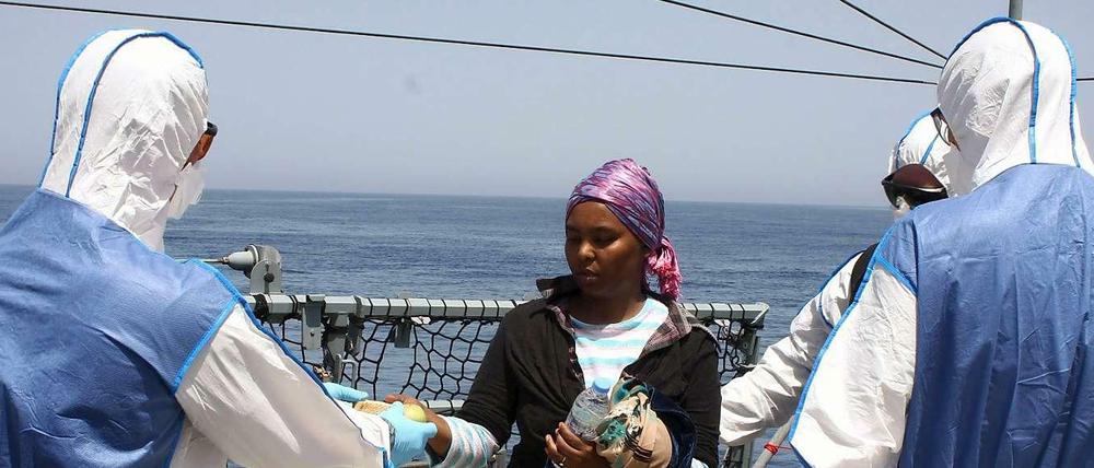 Personal der Bundeswehr verteilt auf der Fregatte "Hessen" Wasser an gerettete Flüchtlinge.