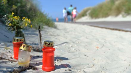Kerzen und Blumen stehen am 05.08.2013 vor dem Aufgang zum Strand auf der Nordseeinsel Juist. Das Landgericht Aurich hatte einen 24-Jährigen wegen Totschlags zu einer Freiheitsstrafe von sieben Jahren und neun Monaten verurteilt. 