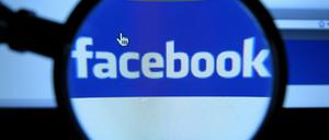 Facebook-Logo auf einem Computer-Bildschirm durch eine Lupe gesehen.