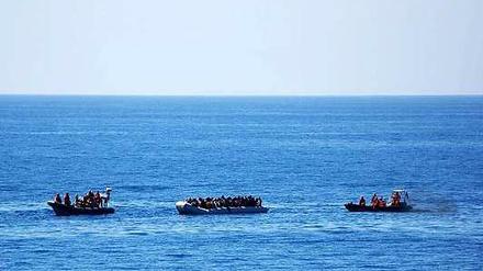 Zwei Rettungsboote der Bundeswehr nähern sich am Donnerstag einem Schlauchboot mit Flüchtlingen.