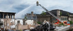 Feuerwehrleute löschen am Himmelfahrtstag ein Feuer in einer Lagerhalle in Karlshorst.
