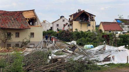 Helfer arbeiten am Donnerstag in Gebenhofen, einem Ortsteil der Gemeinde Affing im Landkreis Aichach Friedberg (Bayern), an beschädigten Wohnhäusern.