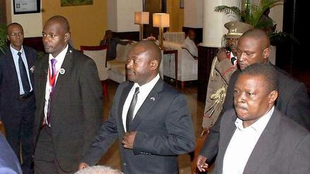 Burundis Präsident Pierre Nkurunziza wird von seinen Sicherheitsleuten aus einem Hotel in der tansanischen Hafenstadt Daressalam geführt. Er machte sich dann auf dem Landweg auf zurück in sein Heimatland. 