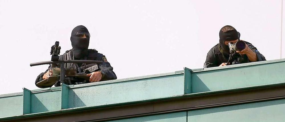 Scharfschützen der Polizei sichern auf Dächern den Staatsbesuch ab.