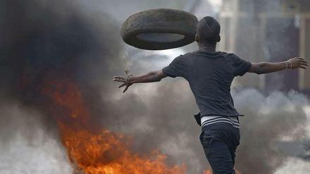 Der Kampf um eine dritte Amtszeit des Präsidenten Pierrre Nkurunziza ist nicht ausgestanden. Ein Demonstrant in der Hauptstadt Bujumbura wirft Reifen auf brennende Barrikaden. Seit mehr als vier Wochen wird in der Hauptstadt fast täglich demonstriert. 