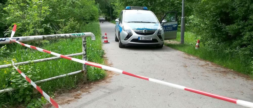 Ein Polizeiauto am Tatort in Kaulsdorf. Die Stelle auf dem Verbindungsweg zwischen Bahnhof Wuhletal und Wohnsiedlung ist mit Flatterband abgesperrt.