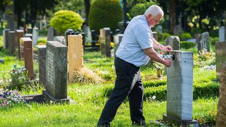 Friedhofsaufseher Reiner Dölfel testet auf dem Pragfriedhof in Stuttgart die Standfestigkeit eines Grabsteins. Auf dem Friedhof müssen Jährlich über 13000 Gräber überprüft werden.