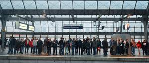 Fahrgäste warten auf einem Bahnsteig des Bahnhofs in Berlin-Spandau auf einen Zug.
