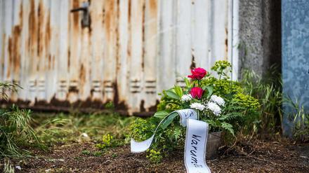 Vor dem verrosteten Tor einer Garage in Großostheim-Ringheim im Landkreis Aschaffenburg (Unterfranken) ein Blumenstrauß zum Gedenken an die dort tot aufgefundene 24-jährige schwangere Frau zu sehen.
