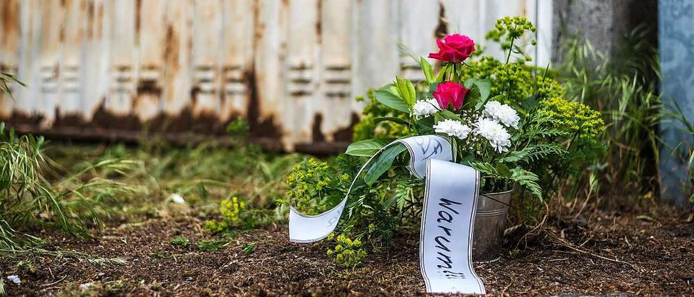 Vor dem verrosteten Tor einer Garage in Großostheim-Ringheim im Landkreis Aschaffenburg (Unterfranken) ein Blumenstrauß zum Gedenken an die dort tot aufgefundene 24-jährige schwangere Frau zu sehen. 