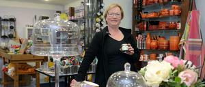 Rote Ecke: Ursula Götz (mit Gewürzdose in der Hand), der Holztisch mit Porzellan.