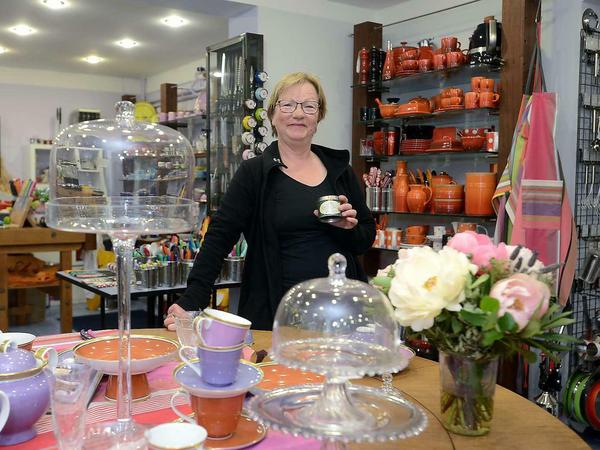 Rote Ecke: Ursula Götz (mit Gewürzdose in der Hand), der Holztisch mit Porzellan.