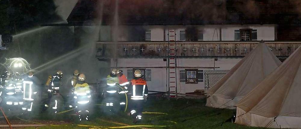 Einsatzkräfte der Feuerwehr kämpfen in Schneizlreuth gegen die Flammen in einem Eventhotel.