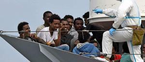 Diese Flüchtlinge haben Glück gehabt. Ein Militärschiff hat sie rechtzeitig aus dem Mittelmeer gezogen. Nun warten Sie darauf, in Italien an Land zu gehen. 