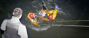 Zwei Feuerwehrleute holen den Schwimmer aus dem Wasser.