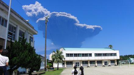 Schulkinder betrachten die Rauchentwicklung am Himmel. Im Südwesten von Japan ist der Vulkan Shindake ausgebrochen. Mehr als neun Kilometer türmten sich die dicken schwarzen Aschewolken über dem Krater auf der Insel Kuchinoerabu in den Himmel. 