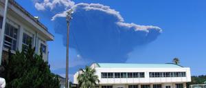 Schulkinder betrachten die Rauchentwicklung am Himmel. Im Südwesten von Japan ist der Vulkan Shindake ausgebrochen. Mehr als neun Kilometer türmten sich die dicken schwarzen Aschewolken über dem Krater auf der Insel Kuchinoerabu in den Himmel. 