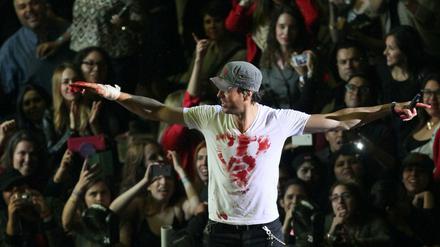 Enrique Iglesias mit blutverschmiertem T-Shirt und verbundener Hand bei seinem Konzert am Samstag in Mexiko. Der Sänger hatte nach einer Drohne gegriffen und sich dabei so schwer verletzt, dass er sich einer Hand-OP unterziehen musste. 