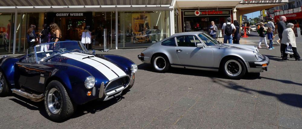 Klassiker der Automobilgeschichte. Eine AC Cobra (links) und ein silberner alter Porsche werben vor dem Neuen Kranzler-Eck für die „Classic Days Berlin“.