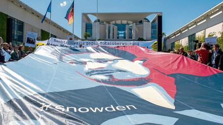 Ein Transparent mit dem Bild von Edward Snowden ist am 30.05.2015 in Berlin bei der Demonstration gegen Massenüberwachung durch Geheimdienste vor dem Bundeskanzleramt gespannt. Aufgerufen hat die Initiative «Rechtsanwälte gegen Totalüberwachung». Anlass ist der zweite Jahrestag der Enthüllungen von Edward Snowden. Foto: Paul Zinken/dpa +++(c) dpa - Bildfunk+++
