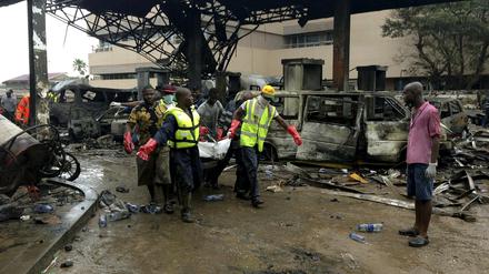 Rettungskräfte tragen eine Leiche aus der explodierten Tankstelle in Accra, Ghana. Am Mittwochabend starben rund 90 Menschen bei der Explosion.