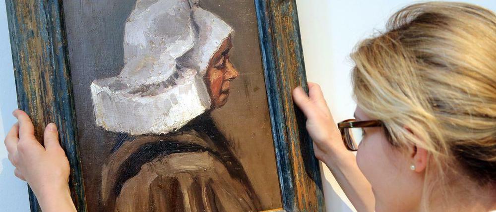 Eine Mitarbeiterin des Auktionshauses Villa Grisebach zeigt ein Gemälde von Vincent van Gogh, "Kopf einer Bäuerin" (1884/1885). Das Bild wurde für 600.000 Euro verkauft.