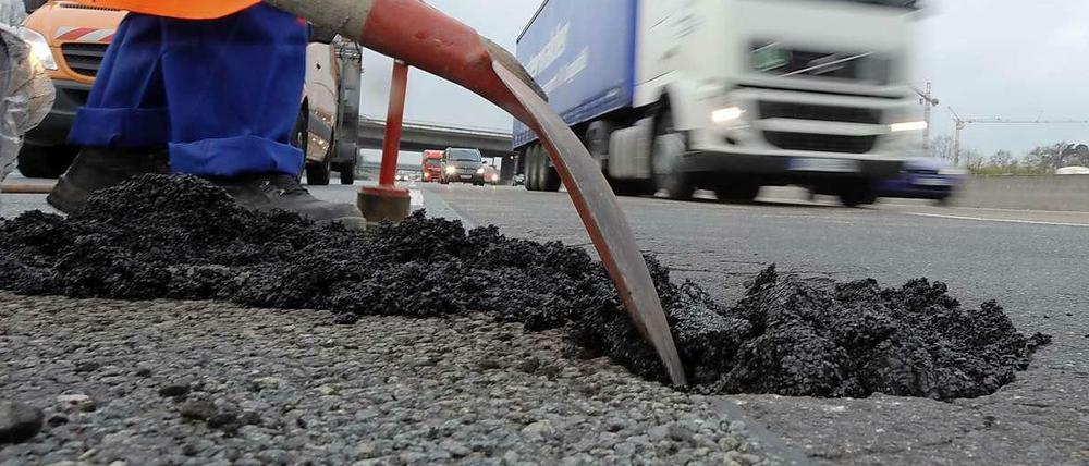 Verfallende Infrastruktur in Deutschland. Ein Schlagloch auf der Autobahn 5 wird gefüllt.