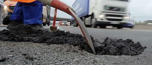 Verfallende Infrastruktur in Deutschland. Ein Schlagloch auf der Autobahn 5 wird gefüllt.