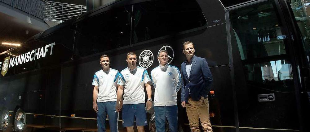 Vier Männer und ein Bus. Manager Oliver Bierhoff (r.) und die Nationalspieler Schweinsteiger, Podolski und Hector präsentieren die neue Marke auf fahrbarem Untersatz.