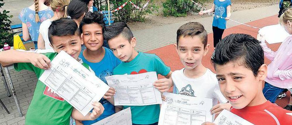 Beim Sportfest der Müggelschlösschen-Grundschule in Köpenick präsentieren Milan (links) und seine Kumpels aus der Willkommensklasse ihre Urkunden.