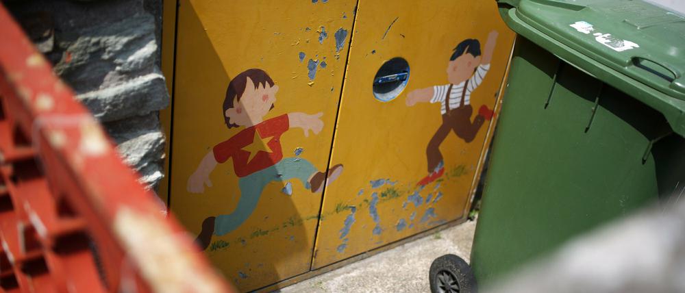 Spielende Kinder sind auf Mülltonnentüren einer Katholischen Kindertagesstätte in Mainz gemalt. Nach mutmaßlichen sexuellen Übergriffen unter Kindern hat die katholische Kirche die Kindertagesstätte vorübergehend dicht gemacht. Die Vorfälle beschäftigen jetzt auch Ermittler und Behörden.