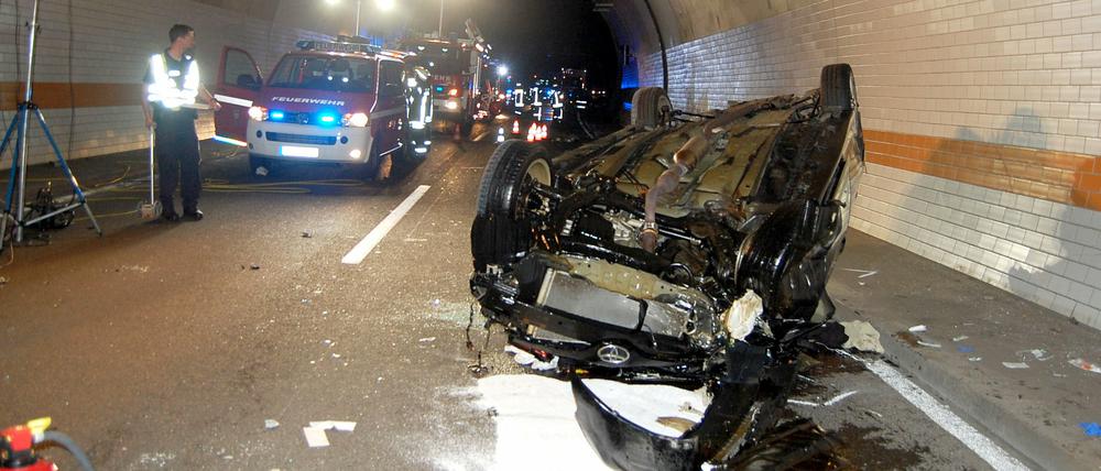 Das Wrack eines zerstörten Autos liegt am Mittwoch nach einem Unfall im Hörnchenbergtunnel auf der Autobahn A62 bei Landstuhl (Rheinland-Pfalz) auf dem Dach. Eine 24-Jährige PKW-Fahrerin war mit dem Wagen an der rechten Tunnelwand die Röhre hinauf, an der Decke entlang und bis zur gegenüberliegenden Wand gefahren, bis der Wagen auf dem Dach nach mehreren Metern zum Stillstand kam. Die Frau kam mit schweren Verletzungen in ein Krankenhaus.