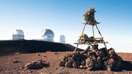 Religion und Wissenschaft. Ein hawaiianischer Tempel auf dem Vulkan Mauna Kea in mehr als 4200 Meter Höhe. Im Hintergrund Teile des Observatoriums. 