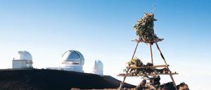 Religion und Wissenschaft. Ein hawaiianischer Tempel auf dem Vulkan Mauna Kea in mehr als 4200 Meter Höhe. Im Hintergrund Teile des Observatoriums.