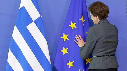 Exakter Faltenwurf. Eine Mitarbeiterin des Protokolls drapiert in Brüssel die Flaggen Griechenlands und der EU.
