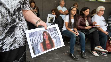 Verwandte, Freunde und Anhaenger von Tugce Albayrak stehen am Dienstag nach der Urteilsverkuendung im sogenannten "Tugce-Prozess" mit Plakaten vor dem Landgericht in Darmstadt. Tugces Grossmutter hält hier ein Plakat mit einem Foto ihrer Enkelin.