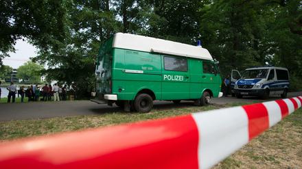 Polizeiwagen stehen am 13.06.2015 in Berlin im Treptower Park. Dort hatten Spaziergänger eine Leiche gefunden. Die Mordkommission ermittelt.