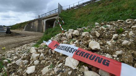 Ein Absperrband der Polizei flattert am 20.10.2014 bei Nellingen (Baden-Württemberg) vor dem Tunnel unter der Autobahn A8, in dem in der Nacht zuvor ein Mädchen von der eigenen Mutter umgebracht worden war.