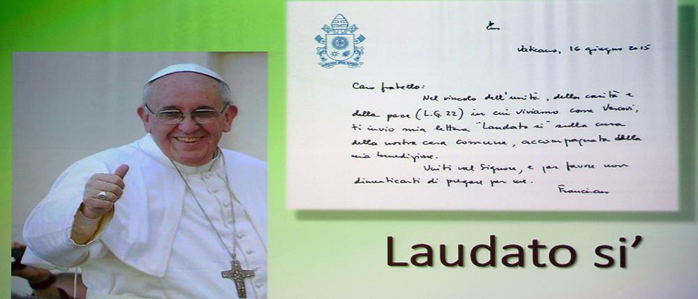 Ein Poster von Papst Franziskus. "Laudato si'" ist der Titel der Umwelt-Enzyklika.