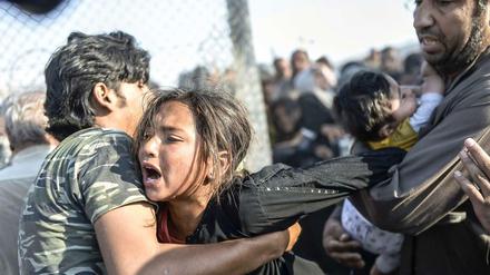 Syrische Flüchtlinge kommen schließlich durch eine Lücke im Grenzzaun in die Türkei.