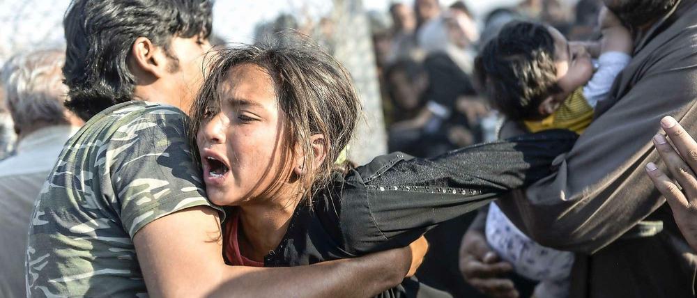 Syrische Flüchtlinge kommen schließlich durch eine Lücke im Grenzzaun in die Türkei.