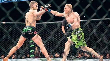 Beim Ultimate Fighting (hier Dennis Siver, rechts, gegen Conor McGregor) ist mehr erlaubt als beim Boxen. Tiefschläge und Tritte gegen den Kopf sind jedoch verboten.
