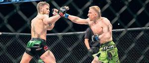 Beim Ultimate Fighting (hier Dennis Siver, rechts, gegen Conor McGregor) ist mehr erlaubt als beim Boxen. Tiefschläge und Tritte gegen den Kopf sind jedoch verboten.