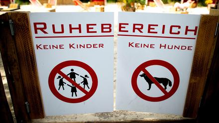Verbotsschilder für Kinder und Hunde sind am Donnerstag in Düsseldorf an einer Tür zum Ruhebereich eines Biergartens angebracht. Mit einer kinderfreien Zone hat sich ein Biergarten-Betreiber Ärger vor allem mit Müttern eingehandelt.