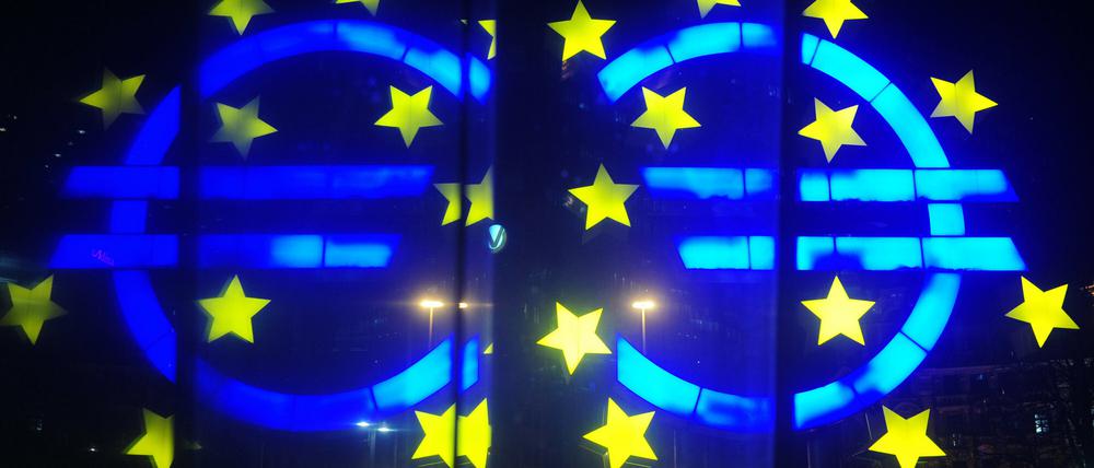Euro im Visier. Die Euro-Skulptur spiegelt sich vor der Europäischen Zentralbank in einer Scheibe. 